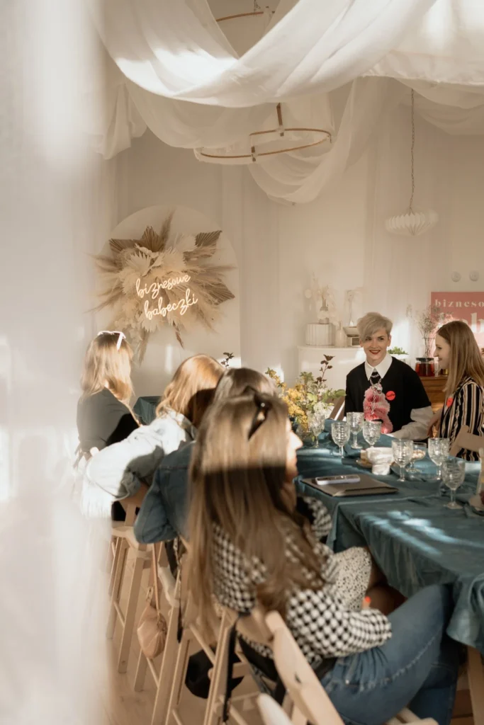 Uczestniczki spotkania biznesowego siedzące przy wspólnym stole w przytulnym wnętrzu