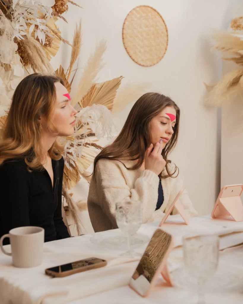 Dwie uczestniczki warsztatów skupione na pracy własnej przy stole w jasnym wnętrzu