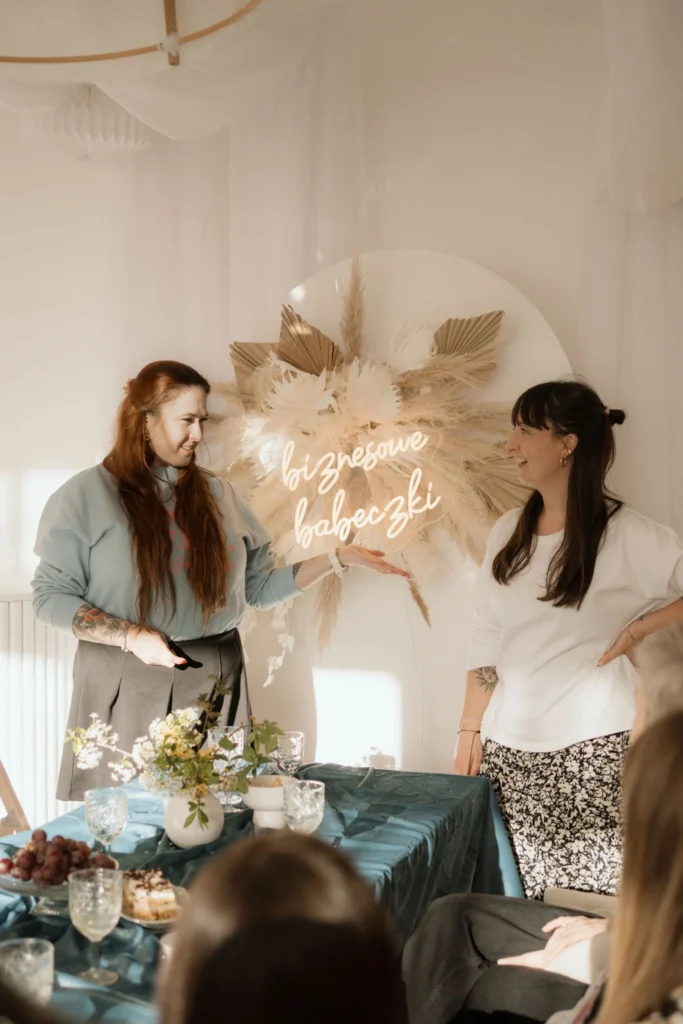 Dwie kobiety prowadzące prezentację podczas kameralnego spotkania biznesowego