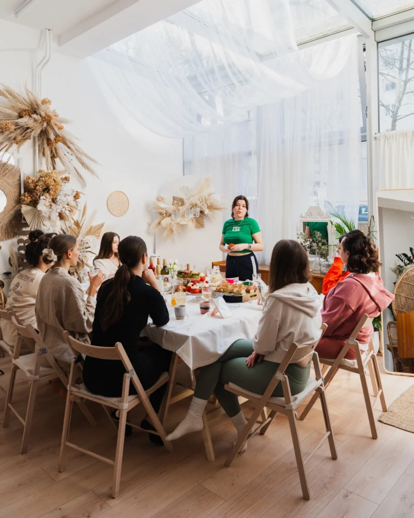 Grupa kobiet siedząca przy stole podczas warsztatów w przytulnym studio