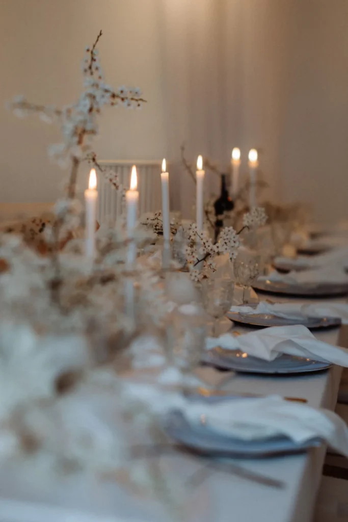 Detale stołu z zapalonymi świecami i kwiatami podczas eleganckiego przyjęcia