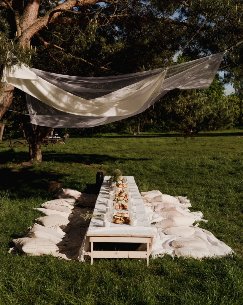 Piknik plenerowy w parku z długim stołem i dekoracją z tkanin