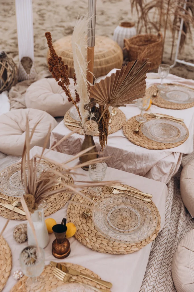 Detale dekoracji pikniku na plaży - boho zastawa, niskie stoły i naturalne dodatki, Chabazie