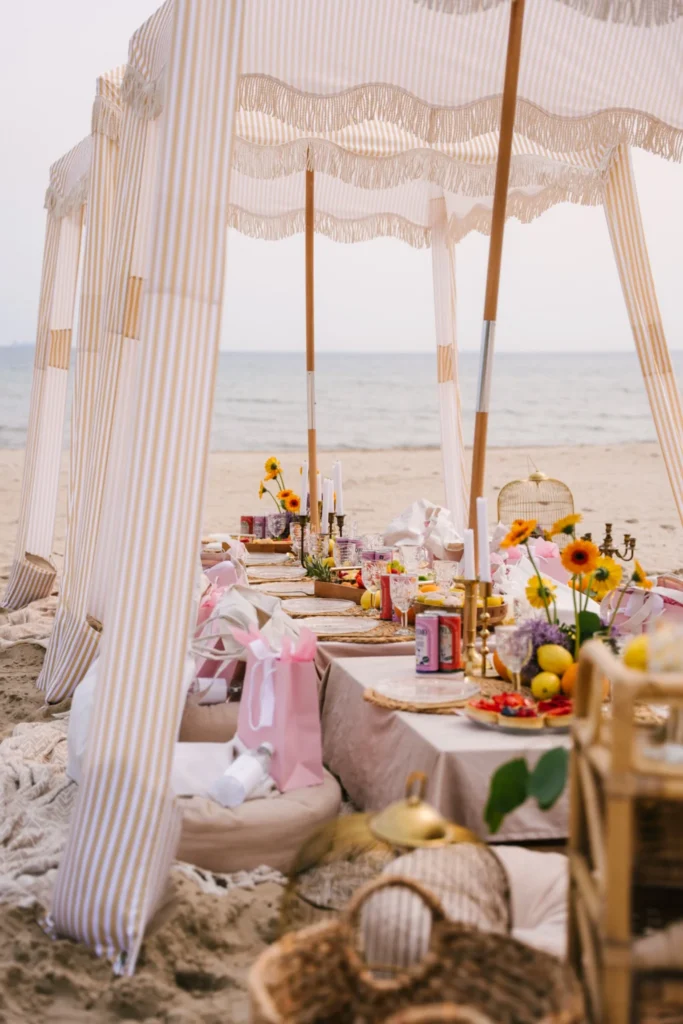 Piknik na plaży z baldachimem i dekorowanym stołem nad morzem
