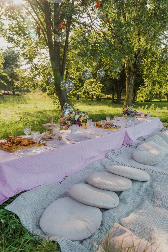 Piknik w parku z długim stołem, kwiatami i dekoracjami