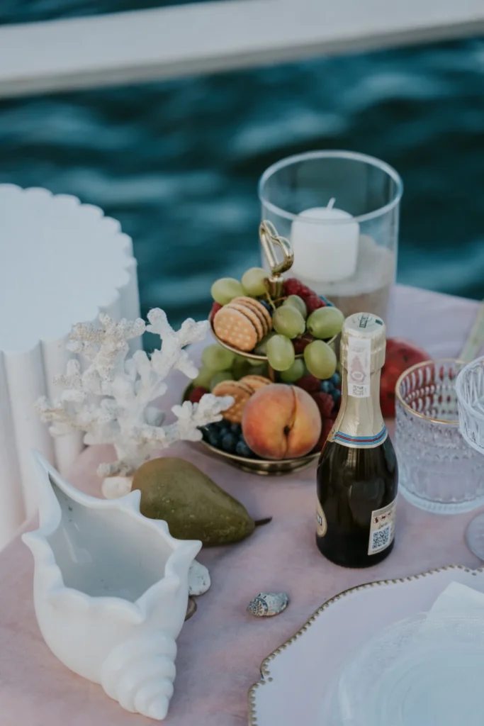 Detal stołu z owocami i świecą przygotowany na zaręczyny premium nad morzem