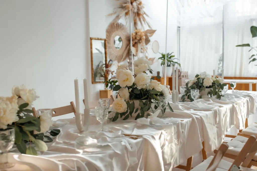 Długi stół z kwiatami i świecami we wnętrzu Chabazie Studio